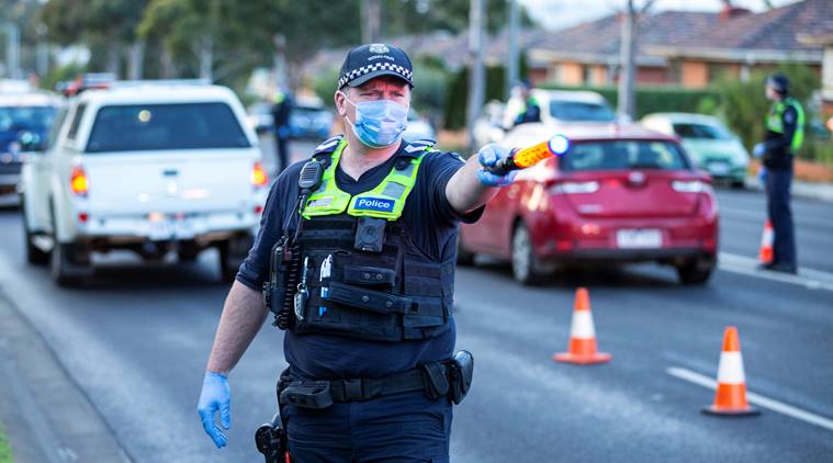 Police stop drivers at a checkpoint as coronavirus disease cases spike in Melbourne