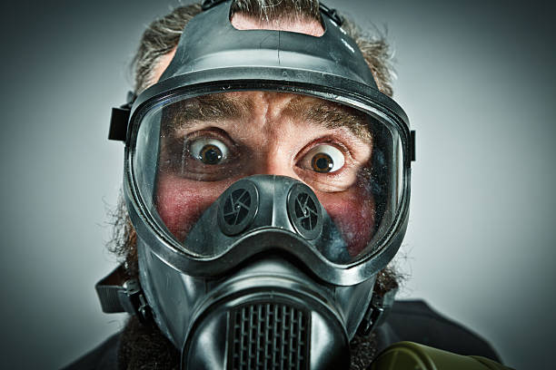 Scared male prepper wearing gas mask
